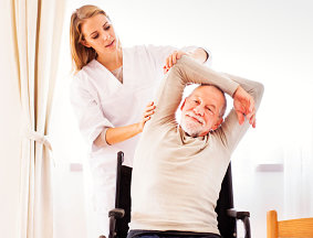 Caregiver assisting the elder man doing exercise